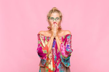 Orta yaşlı bir kadın endişeli, üzgün ve korkmuş hissediyor, elleriyle ağzını kapatıyor, endişeli ve berbat görünüyor.