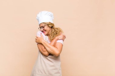 Aşkı hisseden, gülümseyen, kendine sarılan, bekar, bencil ve bencil bir kadın.