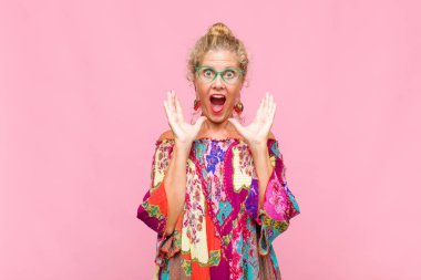 Orta yaşlı bir kadın beklenmedik bir sürpriz yüzünden şaşkın, heyecanlı, gülen, şaşkın ve mutlu hissediyor.