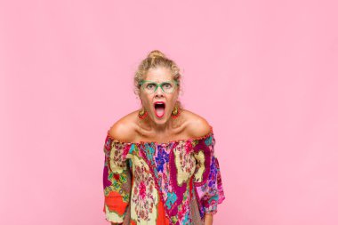 Orta yaşlı kadın korkmuş ve şok olmuş hissediyor, ağzı açık şaşkınlık içinde.