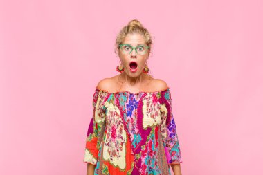 Orta yaşlı bir kadın şok olmuş ya da şaşırmış görünüyor, ağzı açık bir şekilde 