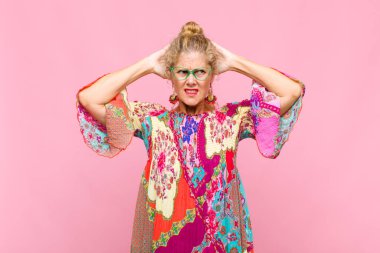 Orta yaşlı bir kadın stresli, endişeli, endişeli ya da korkmuş, elleri başının üstünde, hata yaptığında panikliyor.