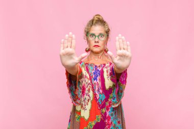 Orta yaşlı kadın ciddi görünüyor, mutsuz, kızgın ve hoşnutsuz giriş yasaklandı ya da her iki avuçta da dur diyor.