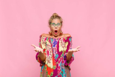 Orta yaşlı bir kadın son derece şok olmuş, şaşırmış, endişeli ve paniklemiş, stresli ve dehşete kapılmış bir şekilde bakıyor.