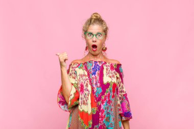 Orta yaşlı kadın inançsızlıktan şaşkın şaşkın bakıyor, yan taraftaki objeyi işaret ediyor ve diyor ki: