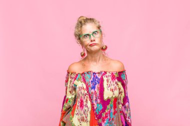 Orta yaşlı bir kadın aptal ve komik görünüyor. Şaşı bakışlı, şakacı ve şakacı.