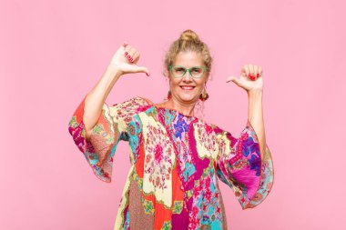 Orta yaşlı bir kadın gururlu, kibirli ve kendinden emin, tatmin olmuş ve başarılı görünüyor, kendini işaret ediyor.