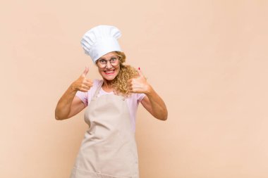 Orta yaşlı fırıncı mutlu, pozitif, kendinden emin ve başarılı bir şekilde gülümsüyor.