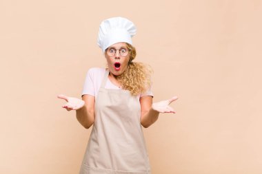 Orta yaşlı kadın fırıncı ağzı açık ve şaşkın, şok olmuş ve hayretler içinde inanılmaz bir sürprizle