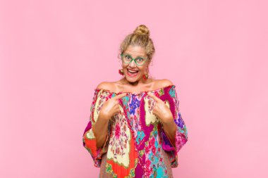 Orta yaşlı bir kadın mutlu, şaşkın ve gururlu hissediyor. Heyecanlı ve şaşkın bir bakışla kendini işaret ediyor.