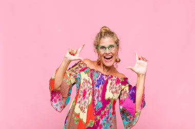 Orta yaşlı bir kadın iki eliyle kendi gülüşünü çiziyor, olumlu ve mutlu görünüyor, sağIık kavramı