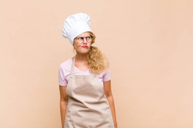 Orta yaşlı fırıncı şaşırmış ve kafası karışmış görünüyor. Bir sorunu çözmeye çalışıyor ya da düşünüyor.