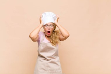 Orta yaşlı bir fırıncı heyecanlı ve şaşırmış görünüyor. İki eli de başının üstünde, kendini şanslı hissediyor.