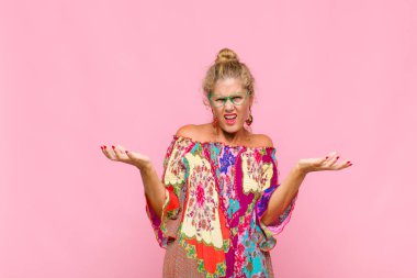 middle age woman shrugging with a dumb, crazy, confused, puzzled expression, feeling annoyed and clueless