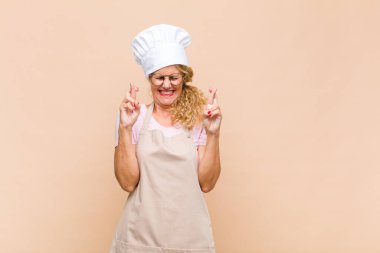 Orta yaşlı fırıncı kendini gergin ve umutlu hissediyor, dua ediyor ve iyi şanslar diliyor.