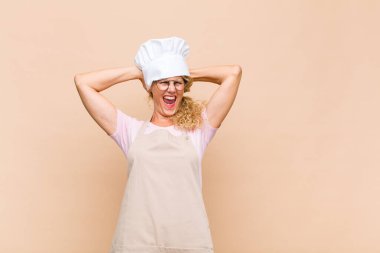 Orta yaşlı kadın fırıncı mutlu, kaygısız, arkadaş canlısı ve rahat görünüyor hayattan ve başarıdan keyif alıyor, pozitif bir tavırla.