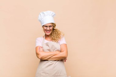 Orta yaşlı bir fırıncı gibi görünen mutlu, gururlu ve tatmin olmuş kollarını kavuşturarak gülümseyen