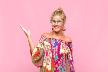 Orta yaşlı bir kadın mutlu, şaşırmış ve neşeli, pozitif bir tavırla gülümsüyor, bir çözüm ya da fikir buluyor.