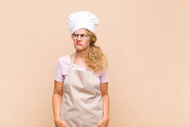 Orta yaşlı bir fırıncı şapşal ve komik görünüyor. Şaşı bakışlı, şakacı ve şakacı.