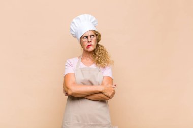 Orta yaşlı fırıncı şüpheci ya da düşünen, dudağını ısıran, kendine güveni olmayan ve gergin hisseden, kenarda yer arayan