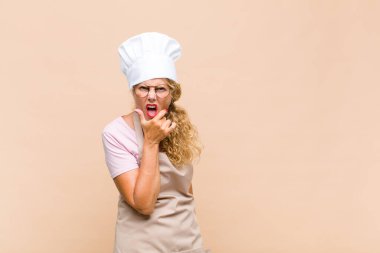 Orta yaşlı fırıncı kadın ağzı ve gözleri sonuna kadar açık ve eli çenesinde, hoş olmayan bir şok geçiriyor, ne ya da vay canına diyor.