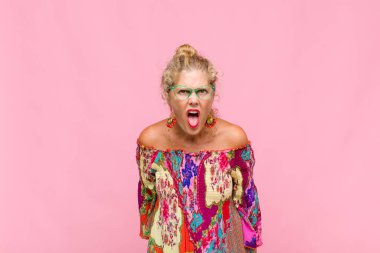 Orta yaşlı bir kadın şok olmuş, kızgın, sinirli ya da hayal kırıklığına uğramış, ağzı açık ve öfkeli görünüyor.