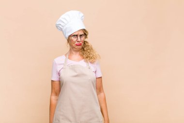 Orta yaşlı fırıncı üzgün ve mızmız, mutsuz bir bakışla ağlayan, olumsuz ve hayal kırıklığına uğramış bir tavır içinde.