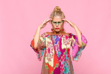 Orta yaşlı bir kadın konsantre olmuş, düşünceli ve ilham verici, beyin fırtınası yapıyor ve hayal kuruyor.