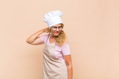 Orta yaşlı bir fırıncı stresli, endişeli, yorgun ve hayal kırıklığına uğramış, gömleğini çekiştirmiş, sorunlu görünüyor.