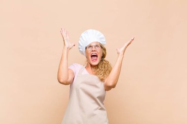 Orta yaşlı fırıncı kendini mutlu, şaşkın, şanslı ve şaşırmış hissediyor. Zaferi iki eli havada kutluyor.