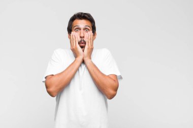 Genç Latin yakışıklı adam mutlu, şaşırmış ve gururlanmış hissediyor, bağırıyor ve başarıyı büyük bir gülümsemeyle kutluyor.