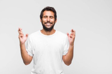 Genç, Latin, yakışıklı, ağzı açık, iki eliyle aşağıya doğru bakan, şaşkın, şaşkın ve şaşırmış görünen bir adam.