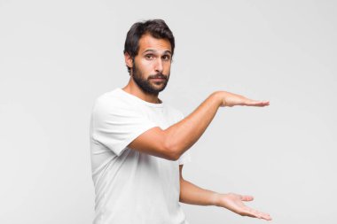 Genç Latin yakışıklı adam bilgisiz ve kafası karışık, hangi seçeneği seçeceğinden emin değil, merak ediyor.