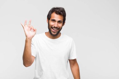 Genç Latin yakışıklı adam ciddi görünüyor, kafası karışık, kararsız ve düşünceli, seçenekler ve seçimler arasında şüpheci.