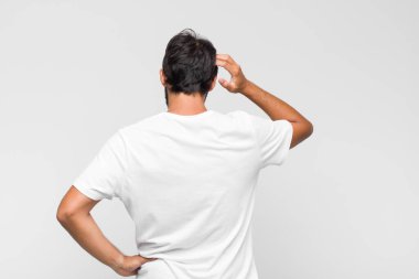 Genç Latin yakışıklı adam hayal kırıklığına uğramış ve hayal kırıklığına uğramış, ciddi görünüyor, kızgın ve kollarını kavuşturmuş.