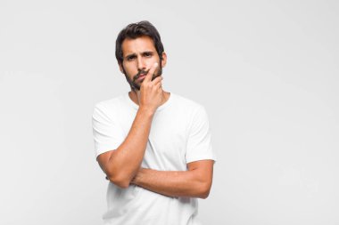 Genç, yakışıklı, yanak tutan ve acı çeken diş ağrısı çeken, hasta, sefil ve mutsuz, dişçi arayan Latin bir adam.