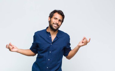 Genç Latin yakışıklı adam mutlu bir şekilde gülümsüyor, şaka yapıyor ve gözetleme deliğinden bakıyor, sırları gözetliyor.