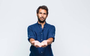 Genç Latin yakışıklı adam boğazı ağrıyan ve grip belirtileri gösteren ağzı kapalı öksüren bir hasta.
