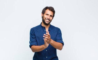 Genç Latin yakışıklı adam gülümsüyor ve arkadaş canlısı görünüyor, bir numara ya da ilk eli önde, geriye doğru sayıyor.