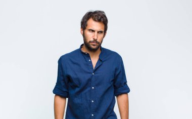 Genç Latin yakışıklı adam üzgün, üzgün ya da kızgın ve olumsuz bir tavır takınıyor, anlaşmazlıkla kaşlarını çatıyor.