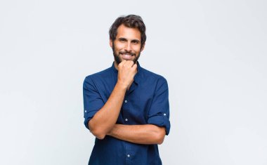 Genç Latin yakışıklı adam gülümsüyor, hayattan zevk alıyor, mutlu, arkadaş canlısı, tatmin olmuş ve tasasız.
