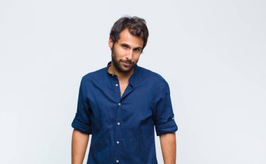 Genç, yakışıklı, gururlu, kendine güvenen, havalı, küstah ve küstah görünen, gülümseyen, başarılı hisseden bir adam.