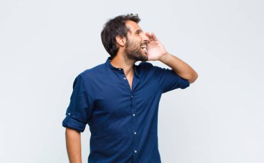 Genç Latin yakışıklı profil görüntüsü, mutlu ve heyecanlı görünüyor, bağırıyor ve kenarda fotokopi için arıyor.