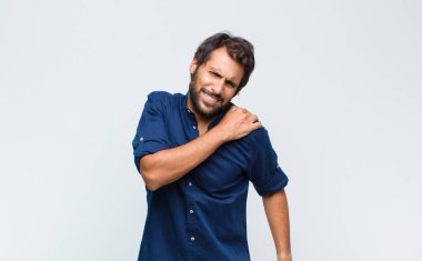 Genç Latin yakışıklı adam endişeli, hasta, hasta ve mutsuz hissediyor. Ağrılı bir mide ağrısı ya da grip geçiriyor.