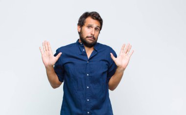 Genç Latin yakışıklı adam gergin, endişeli ve endişeli görünüyor, benim hatam olmadığını söylüyor yoksa ben yapmadım. 