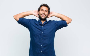 Genç Latin yakışıklı adam mutlu, kaygısız, arkadaş canlısı ve rahat görünüyor hayattan ve başarıdan keyif alıyor, pozitif bir tavırla.