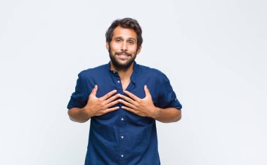 Genç Latin yakışıklı adam mutlu, şaşırmış, gururlu ve heyecanlı görünüyor.