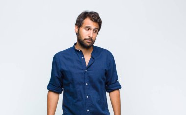 Genç Latin yakışıklı adam merak ediyor, mutlu düşünceler ve fikirler düşünüyor, hayal kuruyor, kenarda yer arıyor.