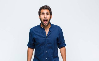 Genç Latin yakışıklı adam korkmuş ve şok olmuş hissediyor, ağzı açık şaşkınlık içinde.