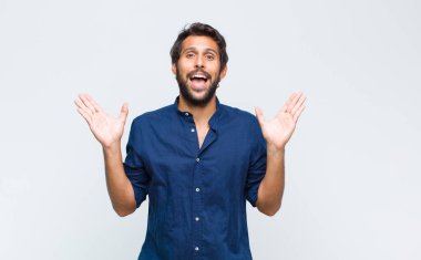 Genç Latin yakışıklı adam mutlu ve heyecanlı görünüyor. Beklenmedik bir sürprizle şoke oldu.